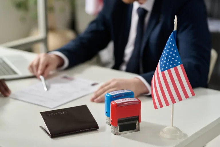 Close up of approved and rejected stamps on table in US immigration office with flag, copy space